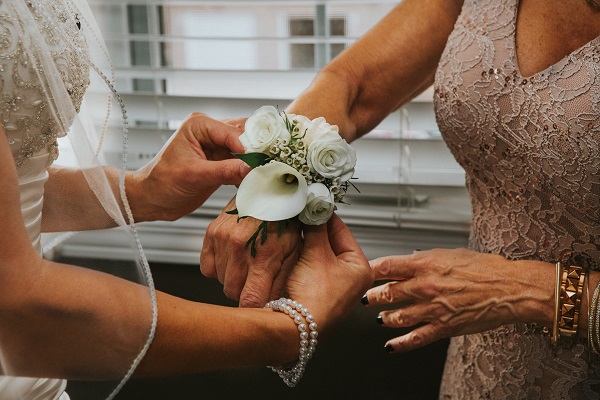 femei la nunta pun floare pe mana