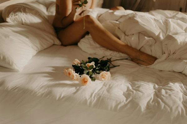 femeie in pat cu flori
