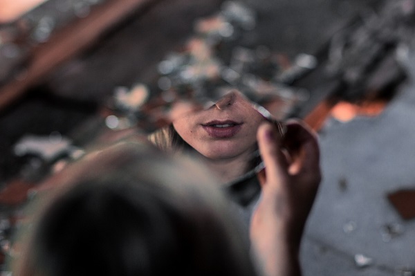 femeie se uita in ciob de oglinda