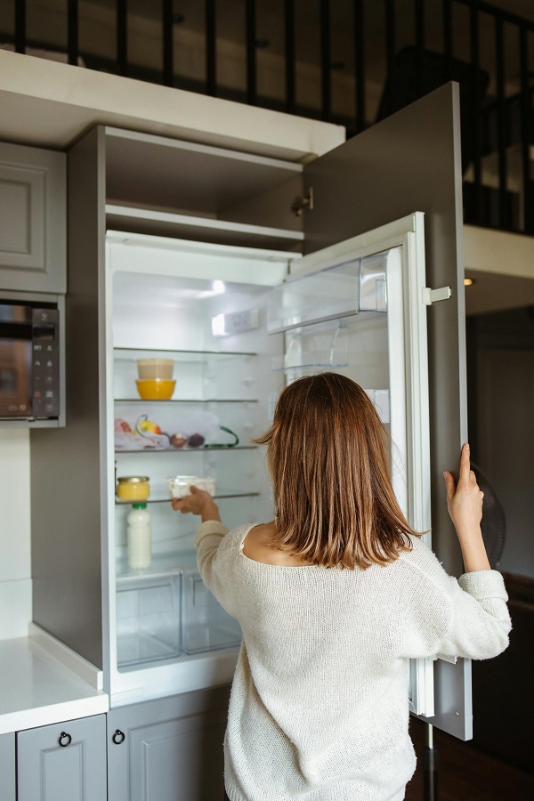 femeie se uita in frigider