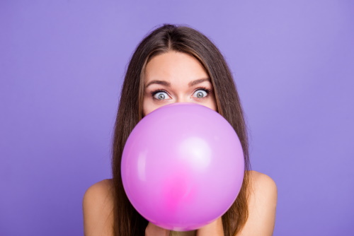 femeie care umfla un balon
