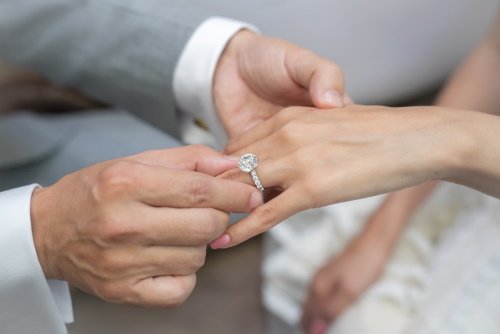 barbat care pune inelul pe degetul unei femei